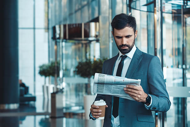 Business Traveller reading the news - Midas Travel Management Business traveller in contact with travel team