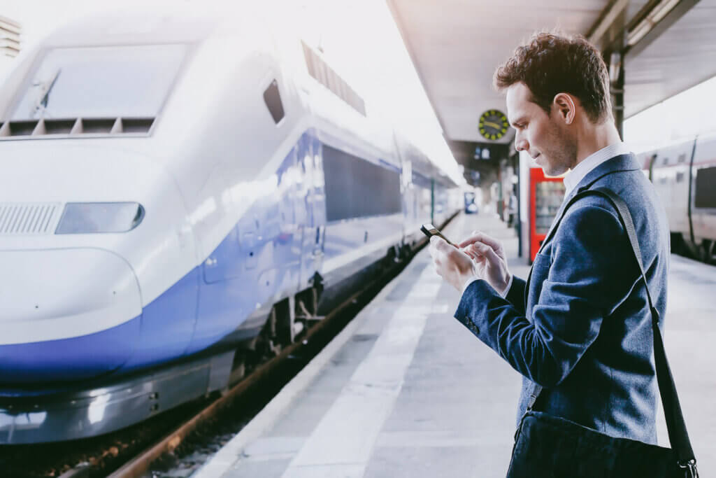 traveller messages travel booker on his mobile for details of his train journey