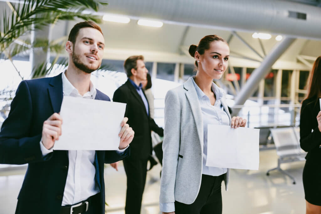 Business people with blank name tags for the guest - Midas Travel Management Meet & greet pick up from the airport can be booked by your travel management company